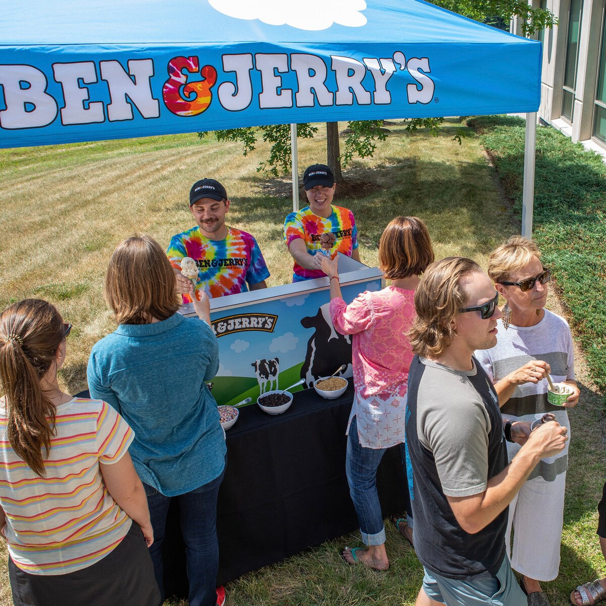 Ben & Jerry's scoopers serving ice cream cones to a group of people